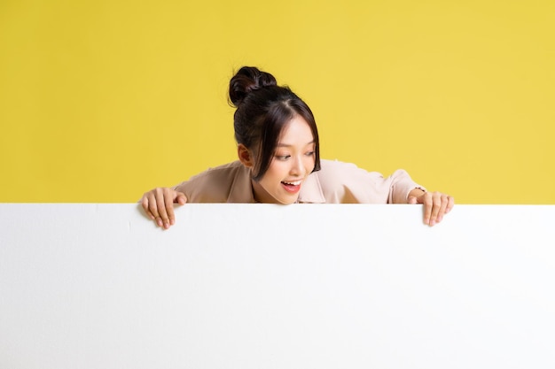 Image of asian girl standing and posing with billboard