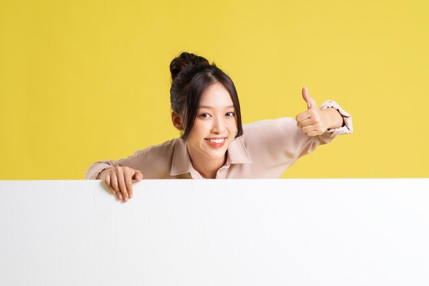Photo image of asian girl standing and posing with billboard