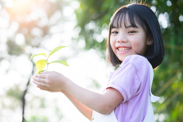 苗木を手に持ったアジアの少女