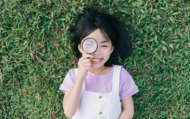 公園で草の上に横たわっているアジアの少女の画像