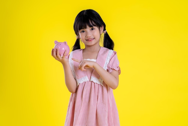 Image of asian little girl posing on a yellow background