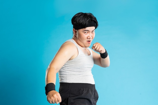 Image of Asian man exercising on blue background