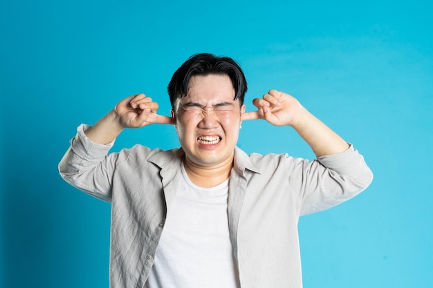 Image of asian man having health problems isolated on blue background