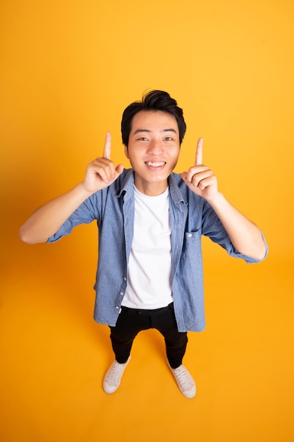 Image of asian man posing on a yellow background