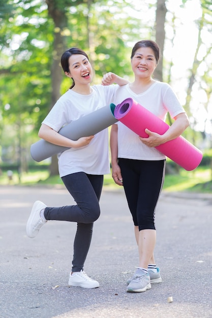 Image of Asian mother and daughter exercise at park