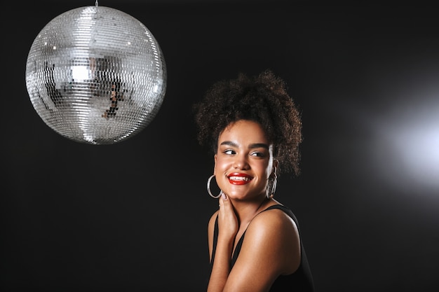 Image of beautiful african woman standing with silver disco ball