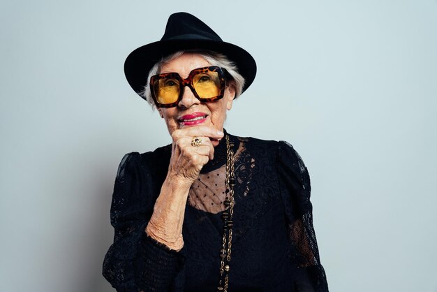 Image of a beautiful and elegant old influencer woman. Cool grandmother posing in studio wearing fashionable clothes