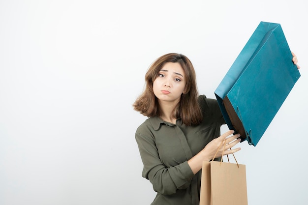 Image of beautiful short-haired girl holding shopping bags. High quality photo