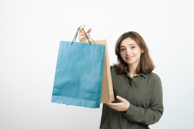 Image of beautiful short-haired girl with shopping bags standing. High quality photo