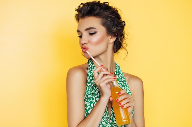 Image of beautiful smiling woman with afro curls isolated over vivid yellow wall background holding cake Say diets NO Happy with sweets