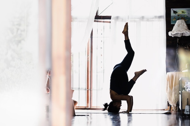 Image of beautiful woman practicing indoor yoga, beautiful girl\
practicing cobra asana in class, peace and relaxation, woman\'s\
happiness, landscape, blurred background.