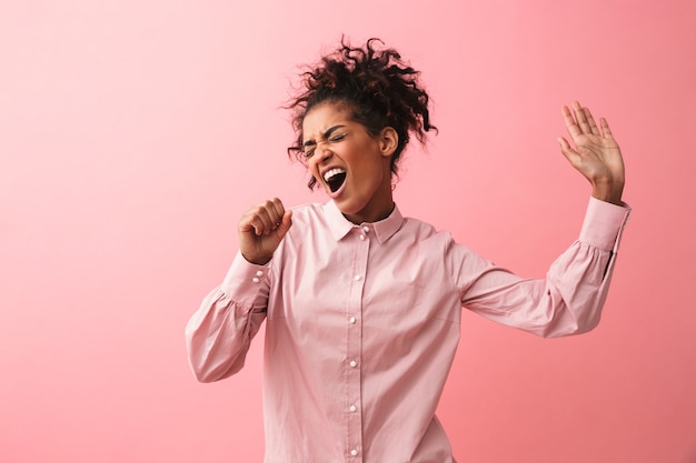 Image of a beautiful young african woman posing isolated screaming singing.