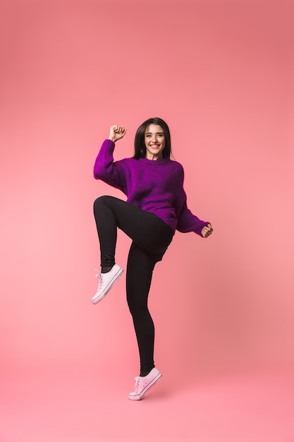 Image of a beautiful young emotional woman posing isolated over pink space make winner gesture.