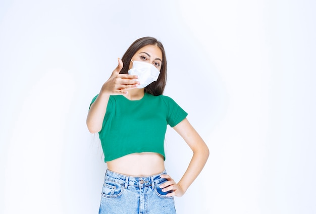 Image of beautiful young girl in medical mask looking at camera and posing. 