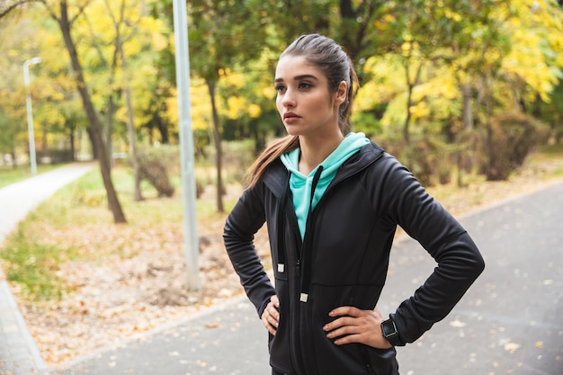 L'immagine di un corridore giovane e bella donna abbastanza fitness ha un periodo di riposo all'aperto nel parco.