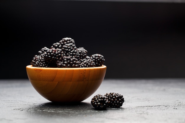 Image of blackberry in plastic container on empty black in studio