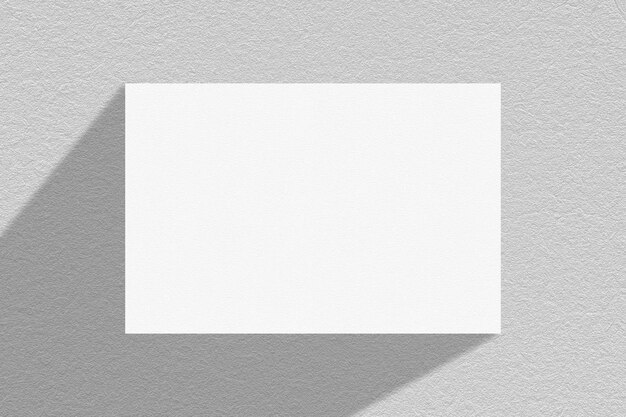 Photo image blank white card on a wall with a light shadow