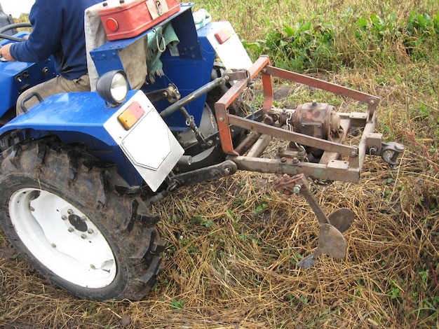 The image of blue tractor with a plough