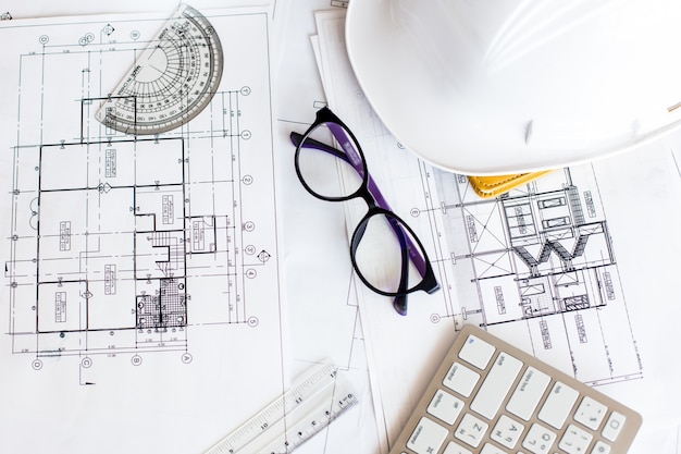 Image of blueprints with level pencil and hard hat on table