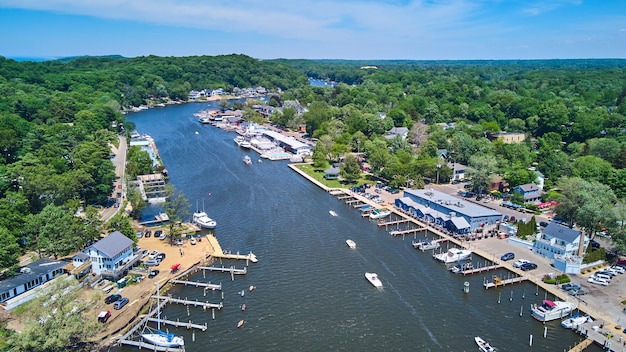 Image of Boats sailing in lake from above with docks and green forest