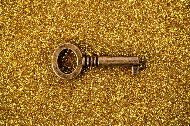 Image of bronze key on a golden background