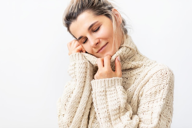 Image of charming young woman with dreaming expression with closed eyes smiling from love and joy over white background Blonde female taking the rest at home