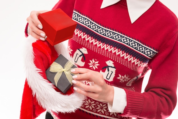 Image of Christmas gifts in a red hat. Holiday concept. Mixed media