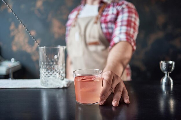 Image of a cocktail glass in the hands of a bartender