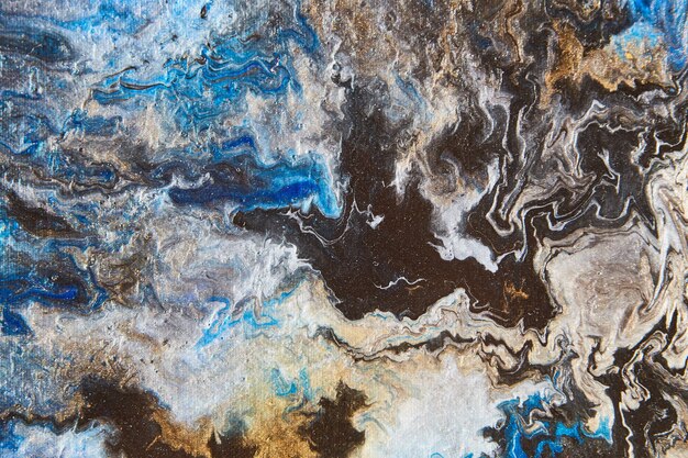 Image of Colorful acrylic pouring on canvas with black, blue, silver, and gold