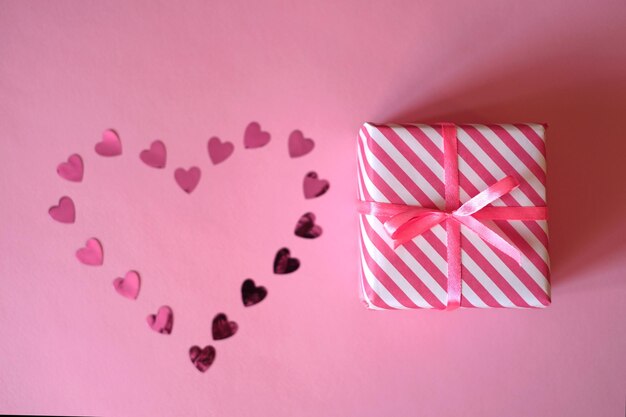 An image of a confetti heart and a gift with a ribbon for Valentine's Day.