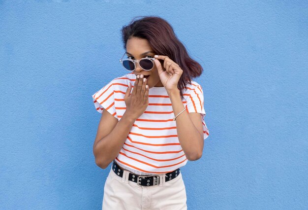 Image of confused african american woman in sunglasses looking at camera