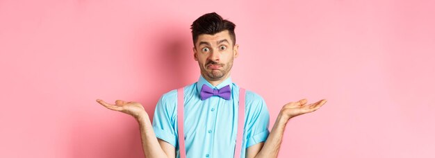 Image of confused guy in bowtie and suspenders know nothing shrugging shoulders and looking clueless