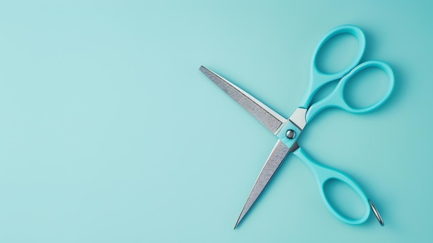 Photo image description a pair of blue scissors is open and lying on a blue background the scissors are made of metal and have a sharp blade
