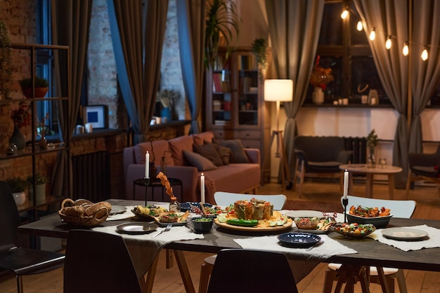 Image of dining table with food and appetizer preparing for\
dinner party in the living room