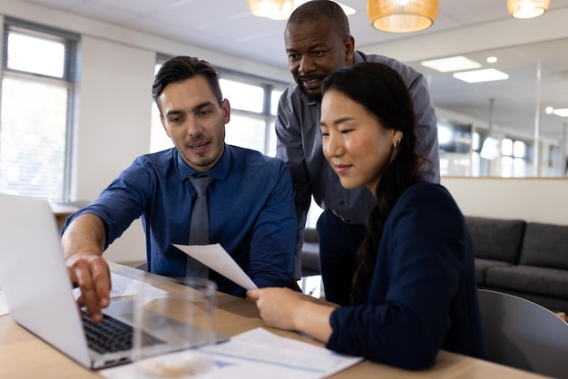 Image of diverse female and male businesspeople working on laptop in office. Business, corporation, working in office and cooperation concept.