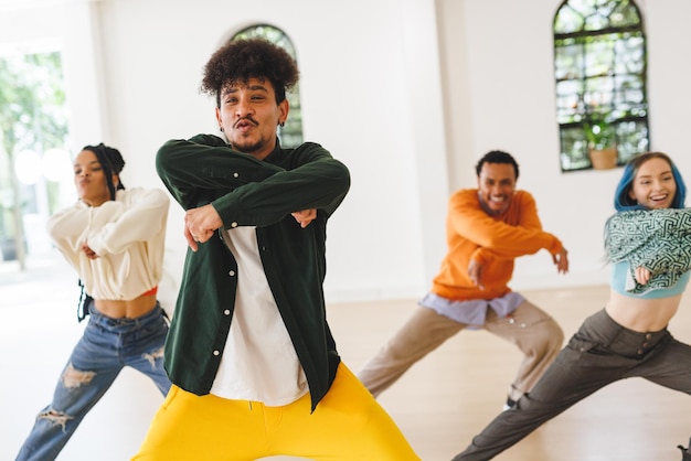 Photo image of diverse female and male hip hop dancers during training in dance club. dance, rhythm, movement and training concept.