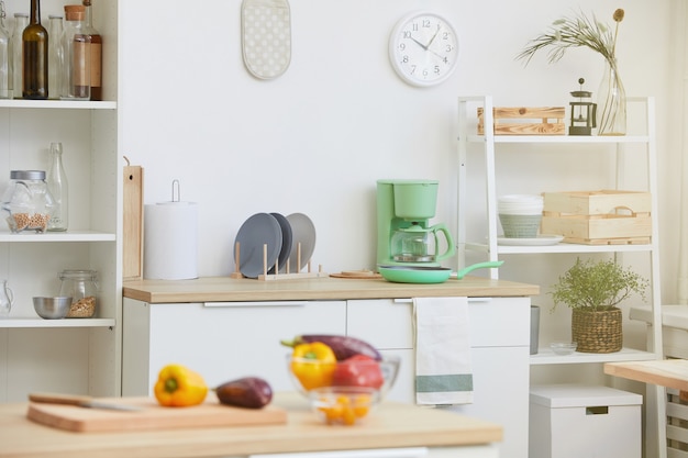 Image of domestic modern kitchen with kitchen table with vegetables on it in the house