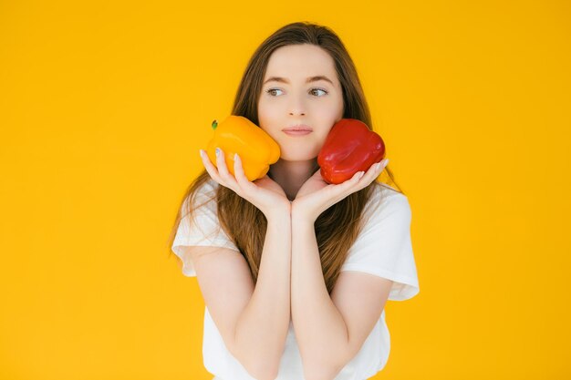 Image of emotional positive young beautiful woman posing and holding paprika