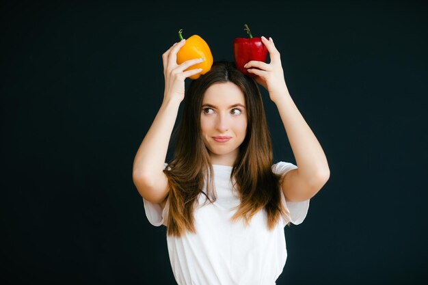 Image of emotional positive young beautiful woman posing and holding paprika