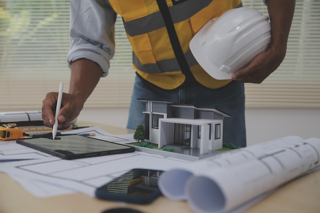 Image of engineer meeting for architectural project working with partner and engineering tools on workplace vintage tone