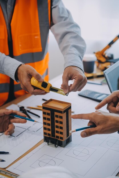 Image of engineer meeting for architectural project working with partner and engineering tools on workplace vintage tone