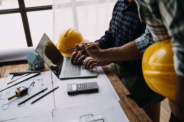 Image of engineering objects on workplace with three partners interacting on background