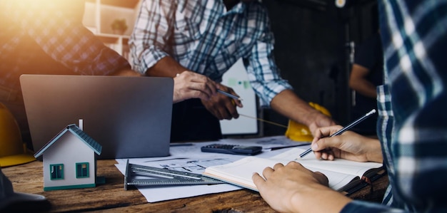 Image of engineering objects on workplace with three partners interacting on background