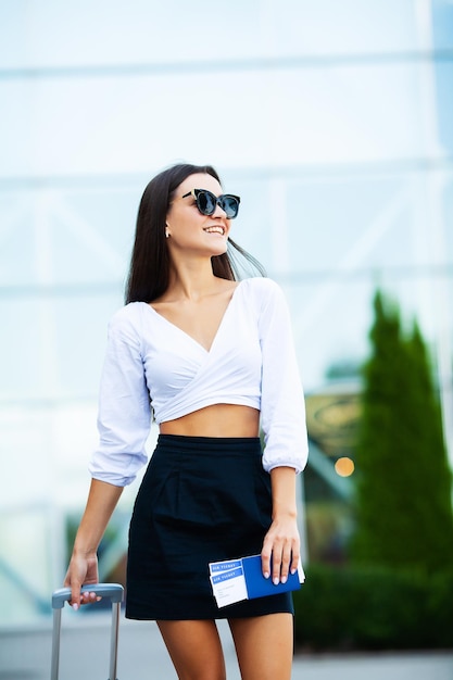 Image of European Woman Having Beautiful Brown Hair Smiling While Holding Passport and Air Tickets