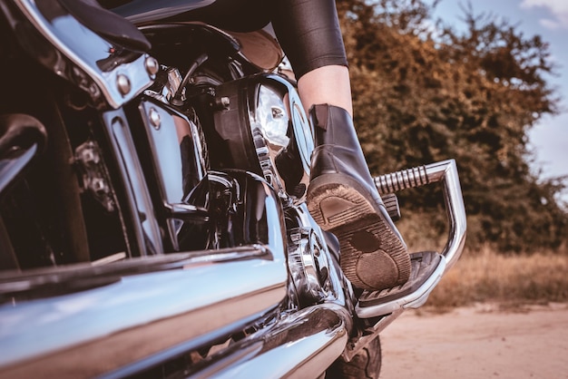 Photo image of a female foot on a motorcycle pedal. travel concept. mixed media