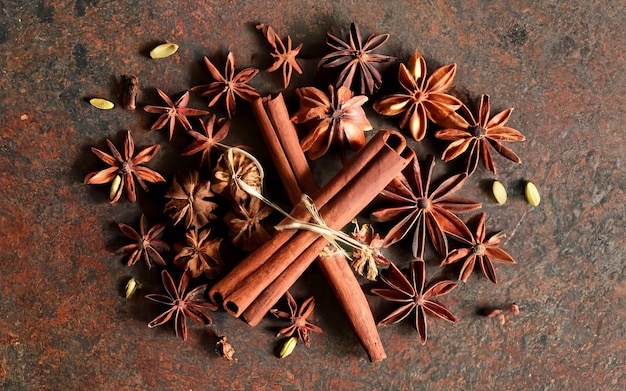 Photo an image of a festive arrangement of holiday spices including cinnamon sticks and cloves