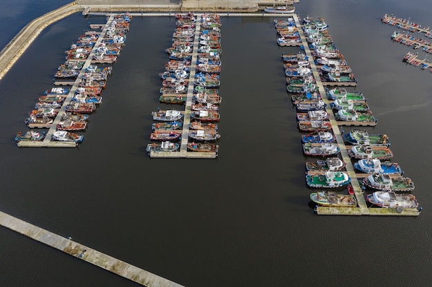 Image of fishing boats on the pier in the port aerial view