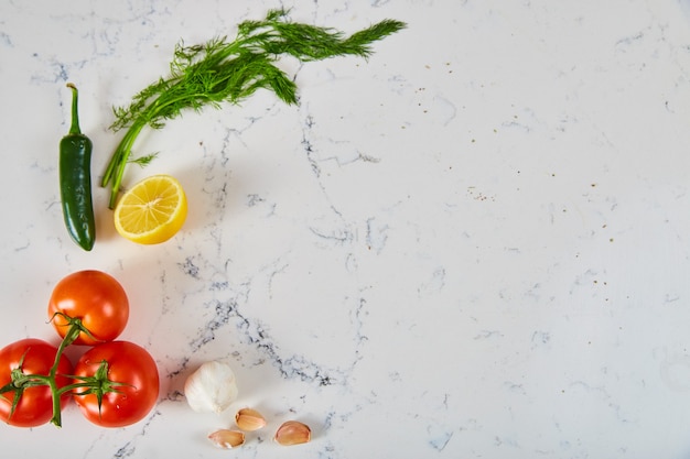 Image of Fresh herbs and produce on white marble surface