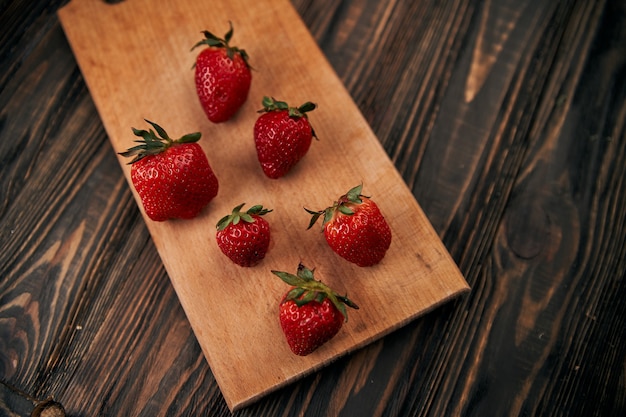 Image of fresh red strawberries on wooden board