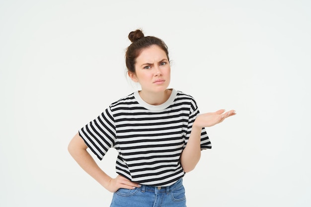Image of frustrated woman complaining looking puzzled shrugging and frowning standing over white